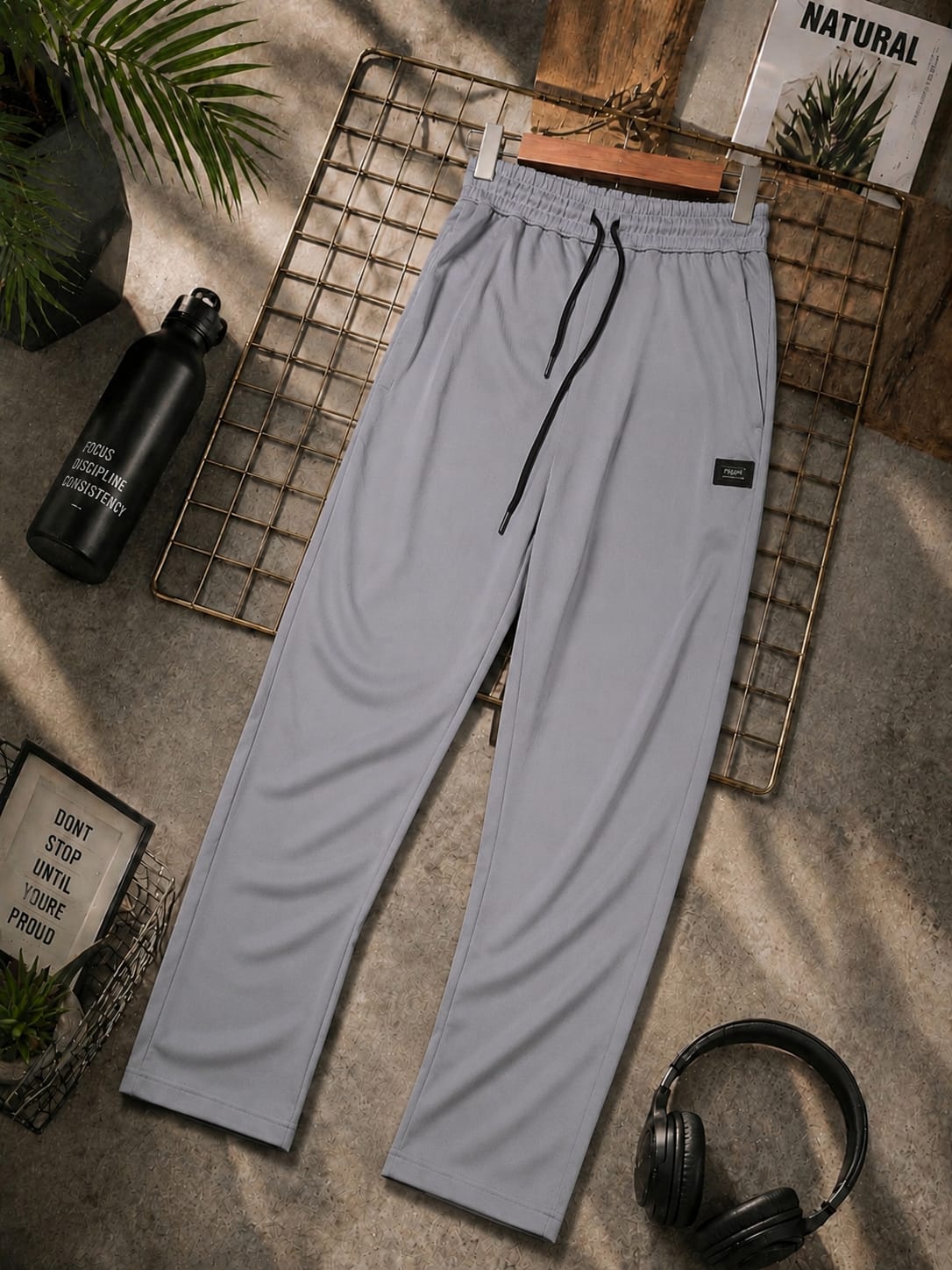 Men’s light grey jogger trousers with elastic waistband, adjustable drawstring and side pockets